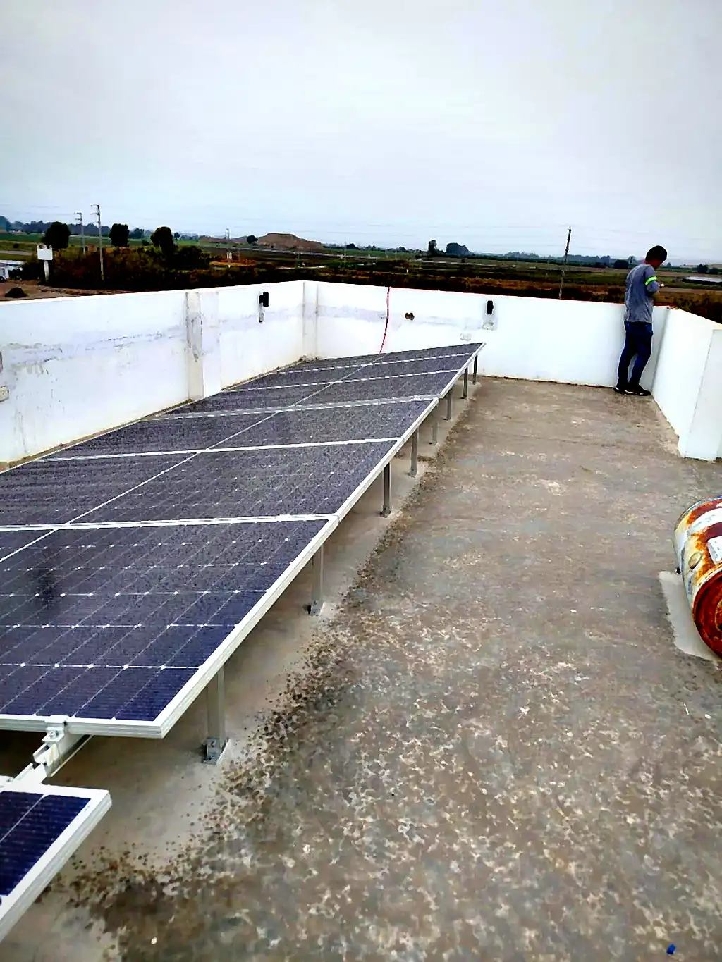 Arreglo de paneles solares en azotea instalado por Compra Solar, con el paisaje de sembríos de Ica al fondo